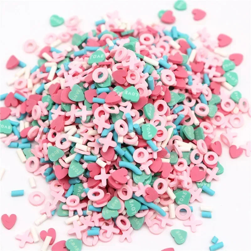 A pile of pink and teal polymer clay flower charms for DIY crafts and decoration