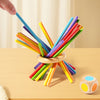 A collection of colorful wooden counting sticks and balance toys arranged in an 'X' shape on a light wooden surface.