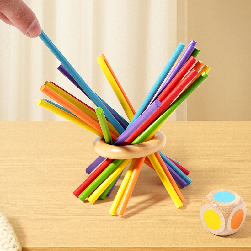 A collection of colorful wooden counting sticks and balance toys arranged in an 'X' shape on a light wooden surface.