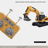 A yellow full-scale remote control excavator truck with a black remote control and a green attachment.