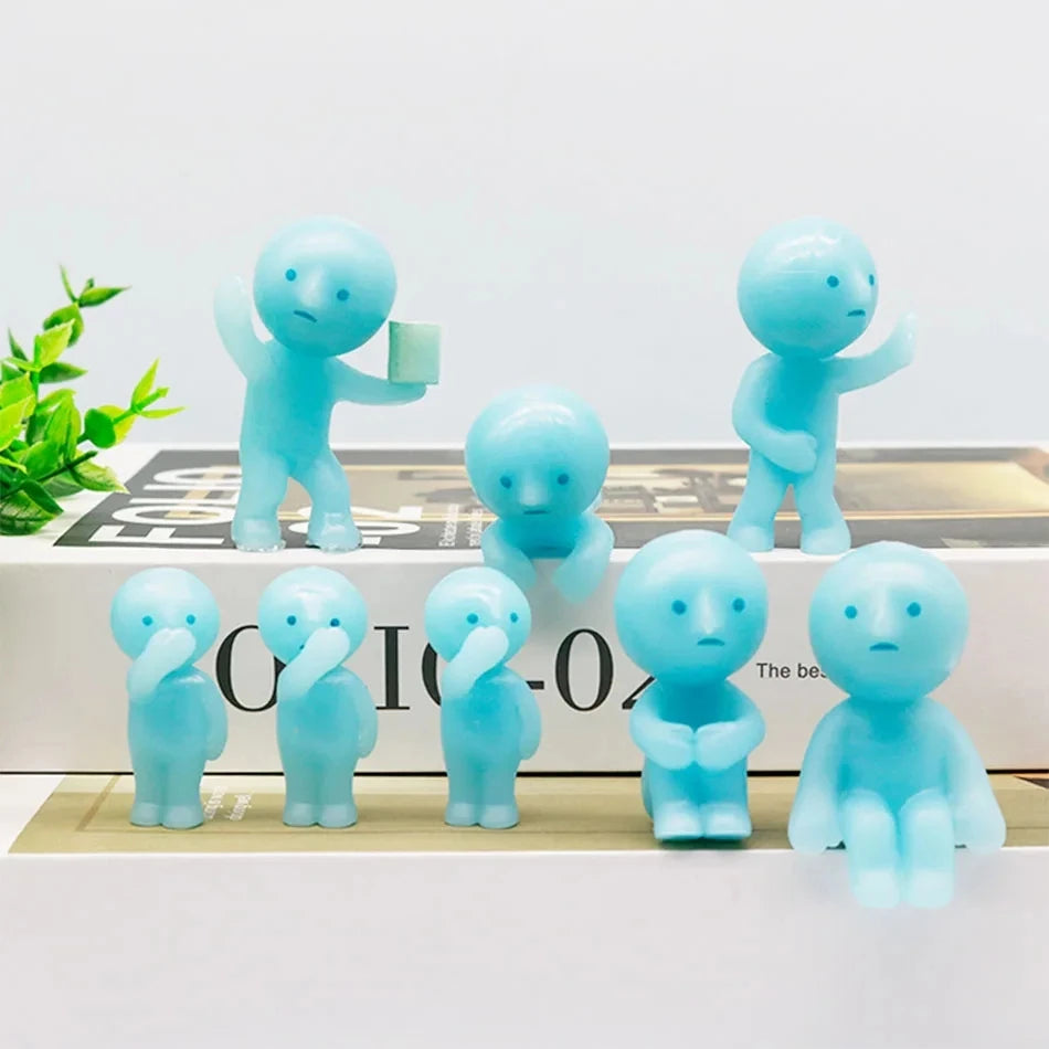 A collection of light blue glow-in-the-dark mini fitness figurines standing on a white surface.