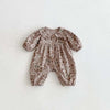 A light beige floral print baby girl jumpsuit with a Peter Pan collar and long sleeves.