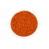 A clear container filled with small, round, orange glass seed beads for jewelry making.