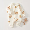 Combinaison en coton blanc pour nourrissons décorée d'appliqués de petits ours bruns.