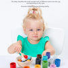 A baby is sorting wooden balls of different colors into corresponding cups for a color matching and classification activity.