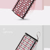 A burgundy portable baby changing mat with a matching storage bag featuring a pattern of pink and white circles.