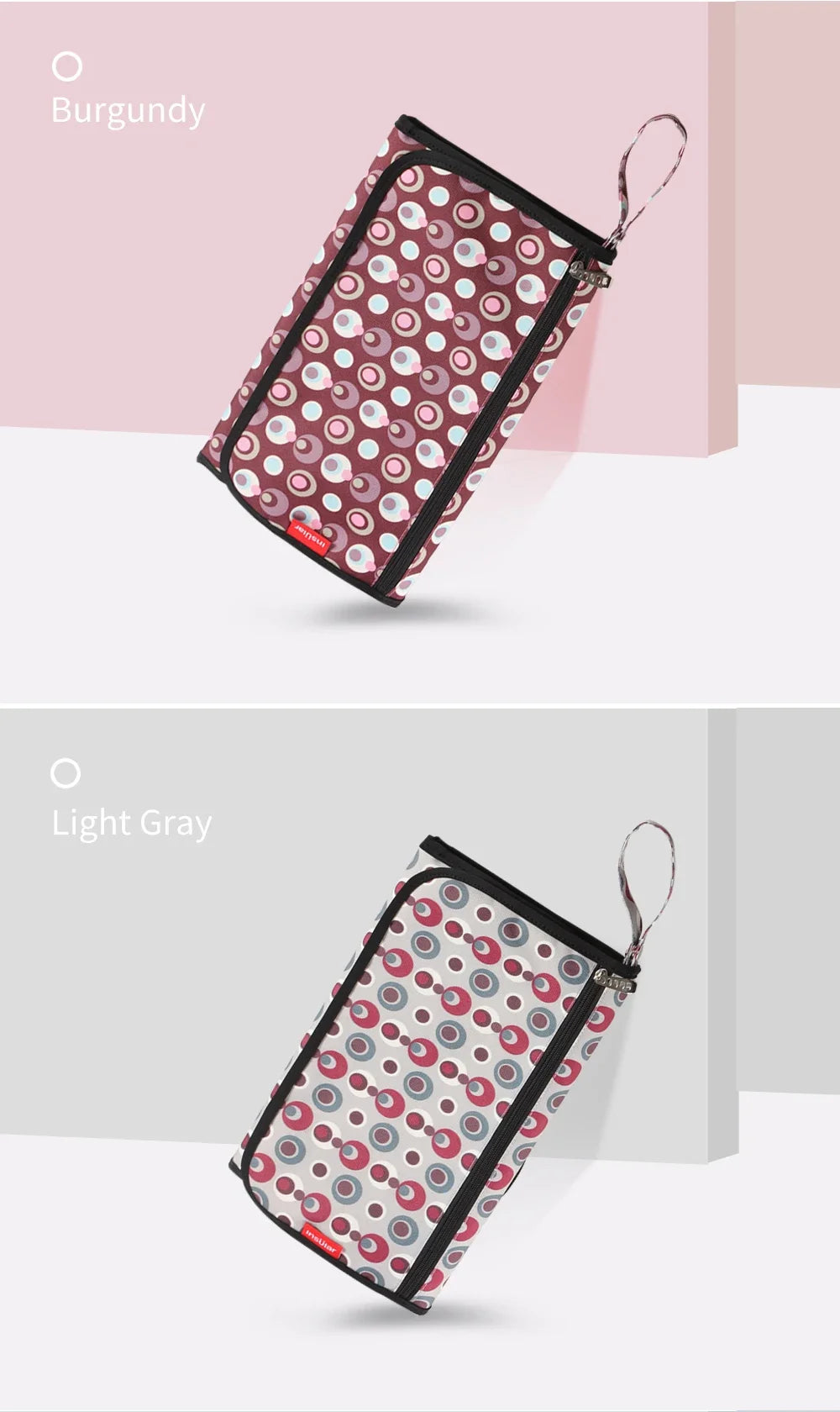 A burgundy portable baby changing mat with a matching storage bag featuring a pattern of pink and white circles.
