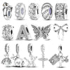 A collection of sterling silver charm beads and pendants for DIY jewelry making including floral, animal, and religious motif