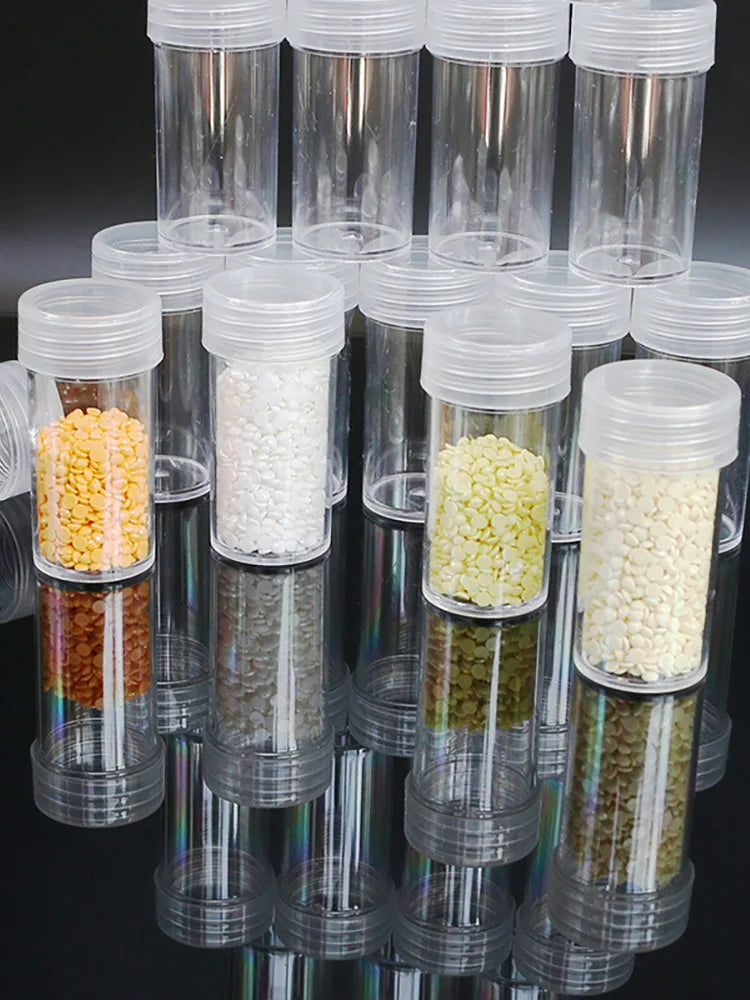 A collection of clear plastic storage bottles filled with various colored beads and craft materials for diamond painting