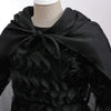 Black chiffon dress with ruffled sleeves and a dramatic black fabric drape worn by a mannequin.