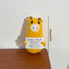 A yellow crochet giraffe pocket hug doll with a white face and inspirational text