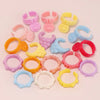 A collection of ten mini pet collar accessories in various pastel colors including pink, yellow, purple, and blue.