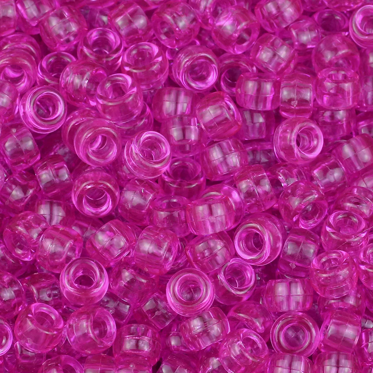 A close-up view of small, translucent pink and purple pony beads for jewelry making and crafts.