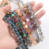 A hand holds a strand of colorful glass star spacer beads for jewelry making