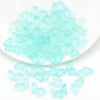 A pile of clear, light blue butterfly glass beads for jewelry making.