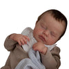 A realistic 19-inch silicone reborn baby doll of a newborn boy with rooted hair, sleeping.