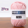 A skein of pink soft chunky t-shirt yarn is shown on a wooden surface.