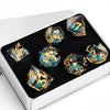 A set of ten translucent resin dice with gold accents displayed in a silver box.
