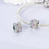 A silver charm shaped like a Rubik's cube with colorful gems is attached to a bracelet chain.