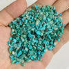 A handful of bright turquoise and green natural tumbled stone chips for jewelry making