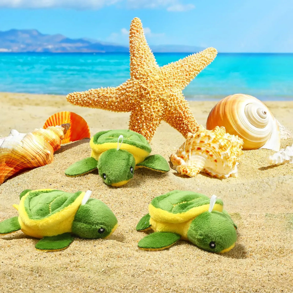 A set of twelve adorable mini sea turtle plush toys resting on sandy beach with seashells and blue ocean background.