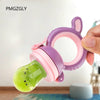 A hand holds a silicone baby food feeder with a green tip and purple/pink ring for teething.
