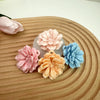 A collection of pink and blue silicone 3D carnation flowers arranged on a wooden surface.