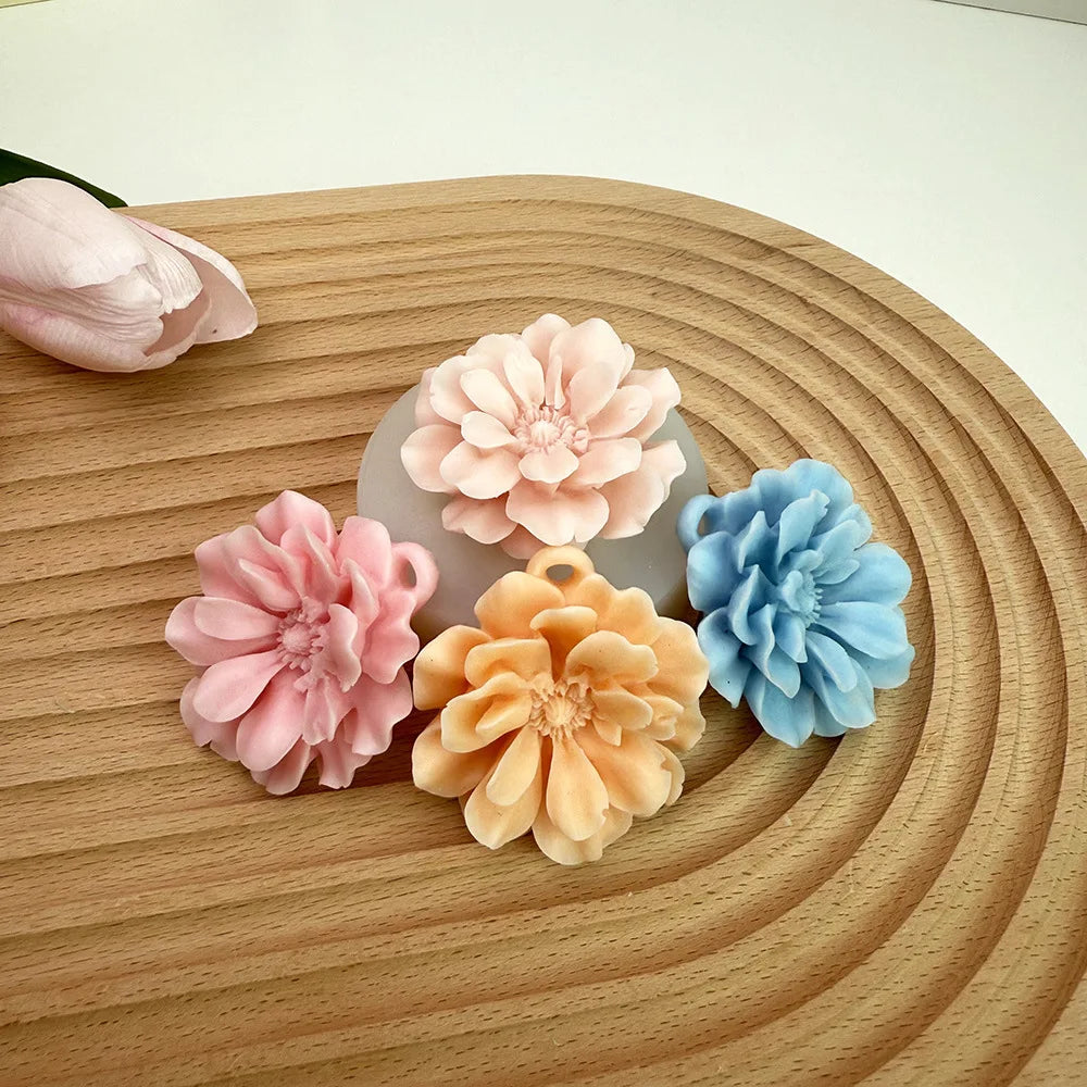 A collection of pink and blue silicone 3D carnation flowers arranged on a wooden surface.