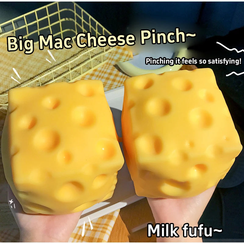 Two yellow cheese squishy fidget toys are held in hands against a blurred background.
