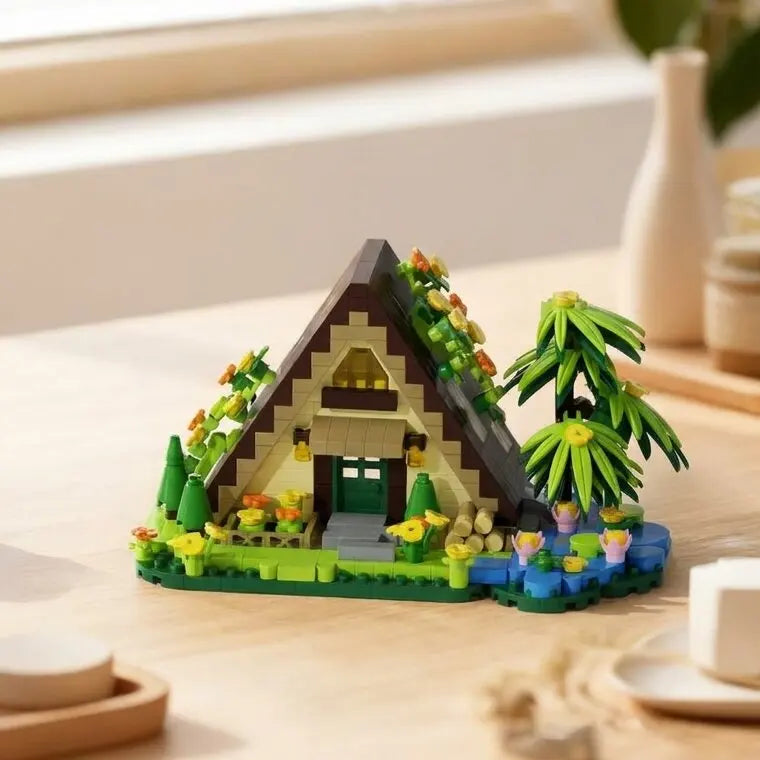 A miniature forest cabin building block set featuring a wooden house, green plants, and yellow flowers.