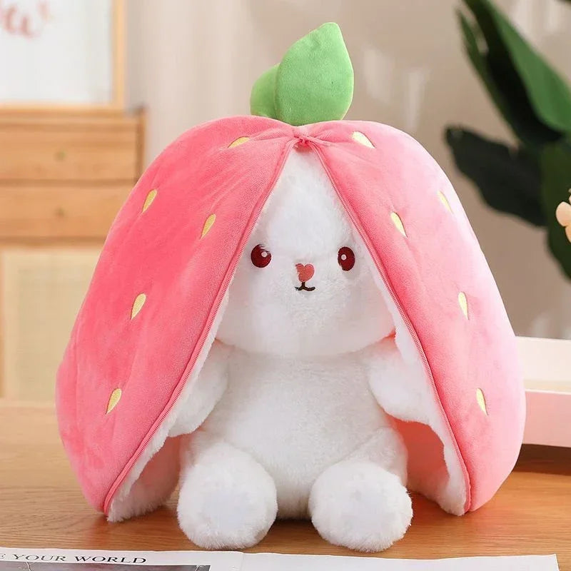 Weißes Hasenplüschtier in Form einer Erdbeere mit rosa Blütenblättern und grünen Blättern.
