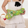 A person is holding a bright green cartoon snake plush toy with large eyes and textured skin.