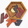 A wooden tangram puzzle set with various geometric shapes arranged inside a hexagonal wooden tray.