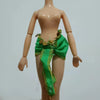 A fashion doll wearing a bright green fabric outfit with gold accents.