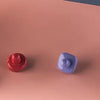 A close-up view of a white magnetic doodle drawing board with various colored magnetic shapes on a pink surface.