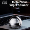 A silver metal fidget spinner resting on a dark laptop surface.