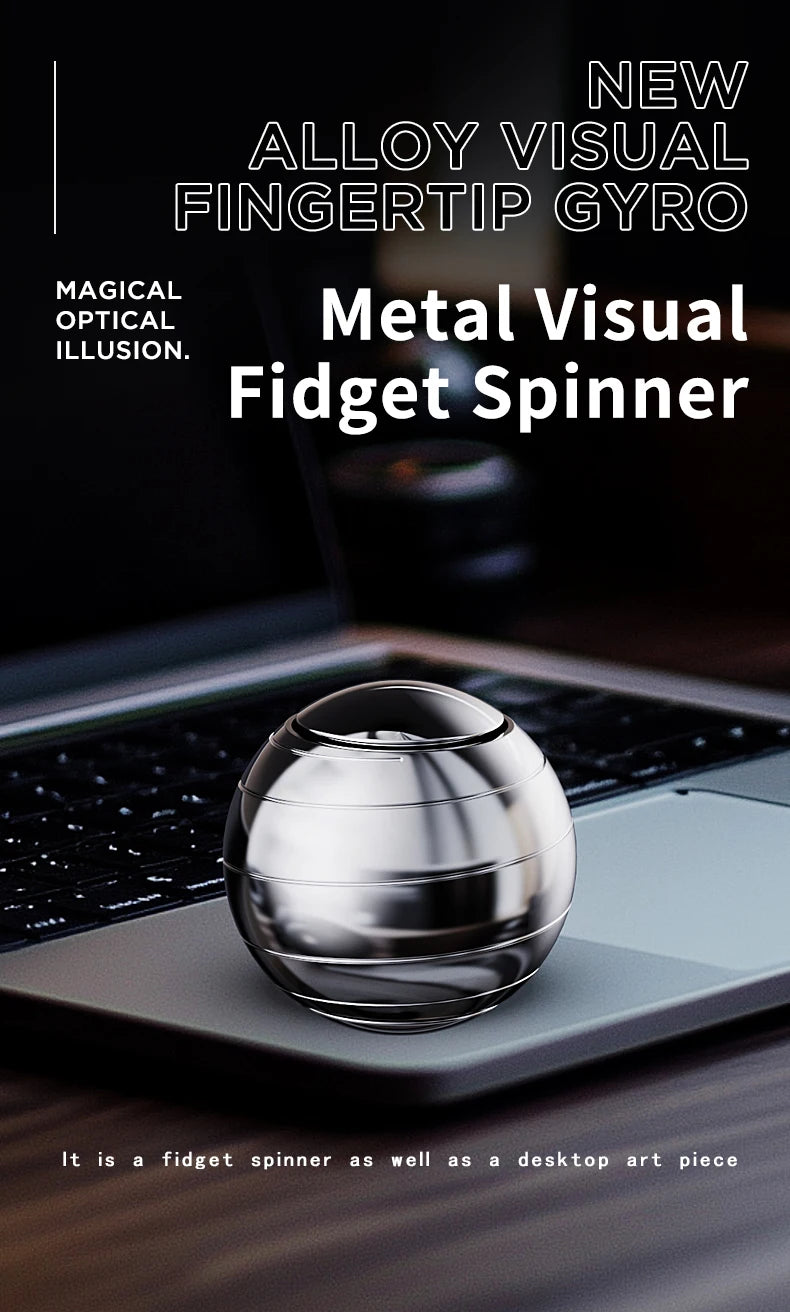 A silver metal fidget spinner resting on a dark laptop surface.