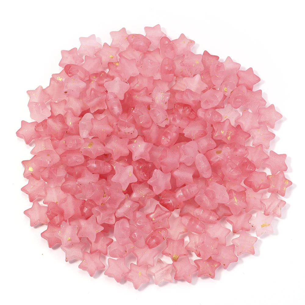 A pile of pink and clear star-shaped acrylic beads for jewelry making