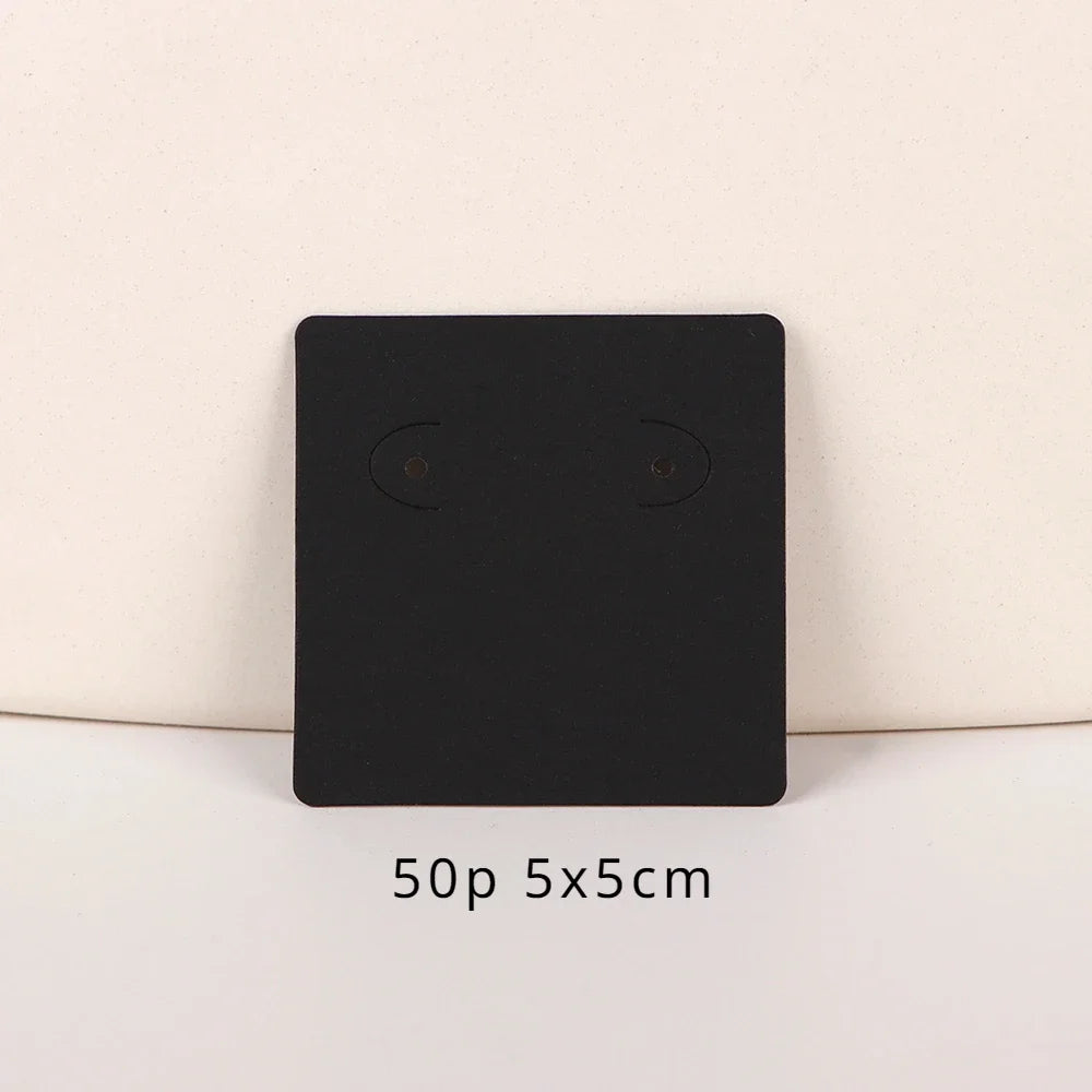 A black square jewelry display card with two circular openings is shown against a light background.