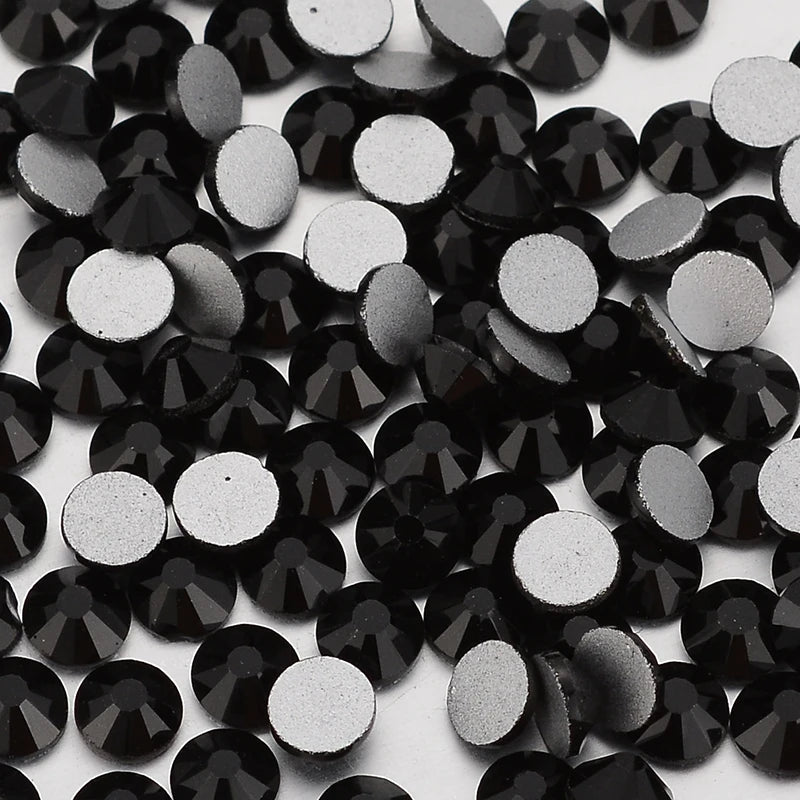 A close-up view of small, round black and silver glass crystal flatback rhinestones.