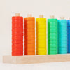 A wooden ring toss game with colorful stacking rings in shades of orange, yellow, and green.