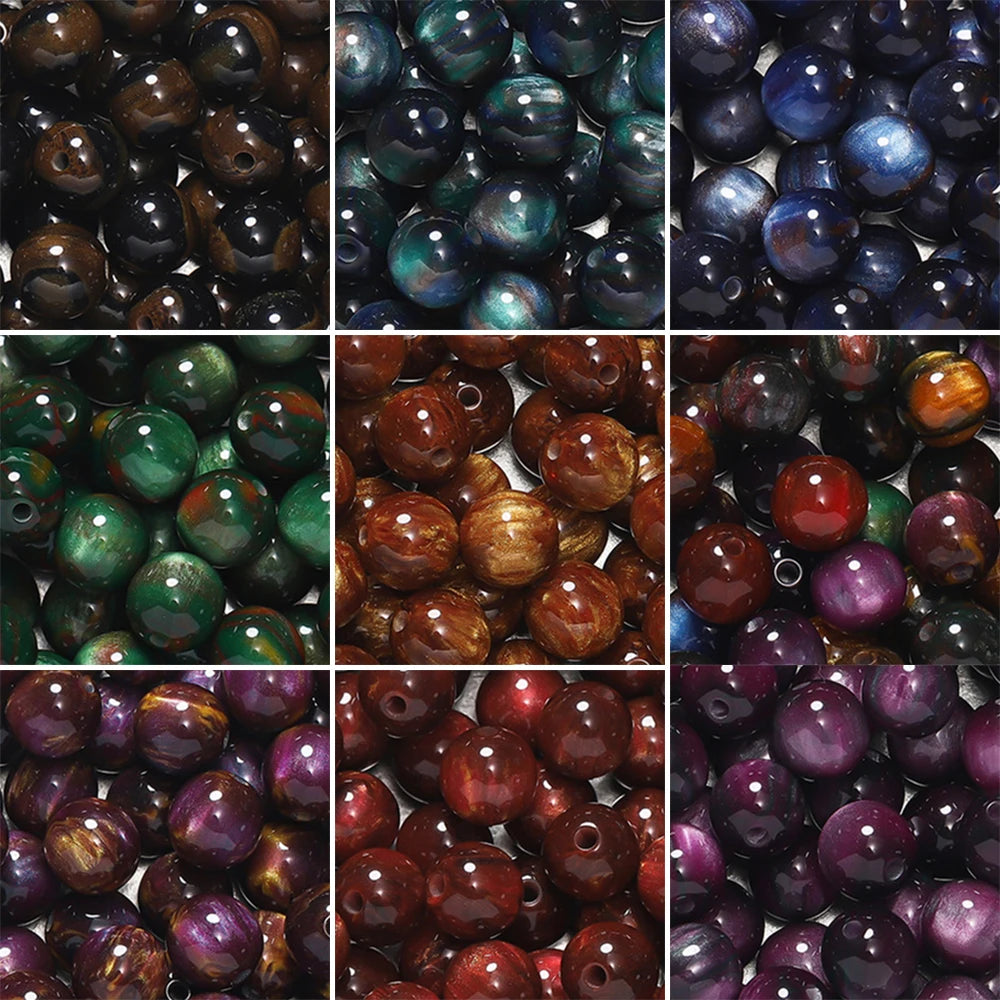 A collection of round, iridescent resin beads in various shades of purple, green, and brown for jewelry making.