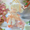 A white and peach collectible figurine of a girl with blonde hair and a golden halo.