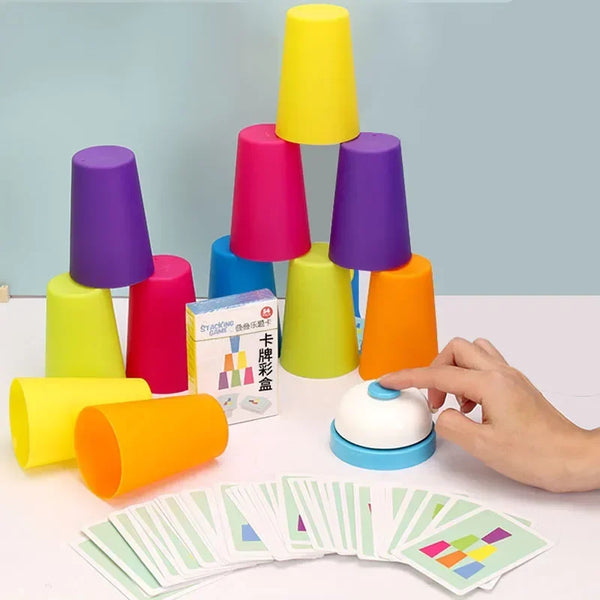 A hand holds a set of colorful stacking cups, including purple, pink, yellow, and orange, next to a fan of small cards.