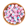 A wooden bowl filled with pink and white patterned silicone beads for jewelry making.