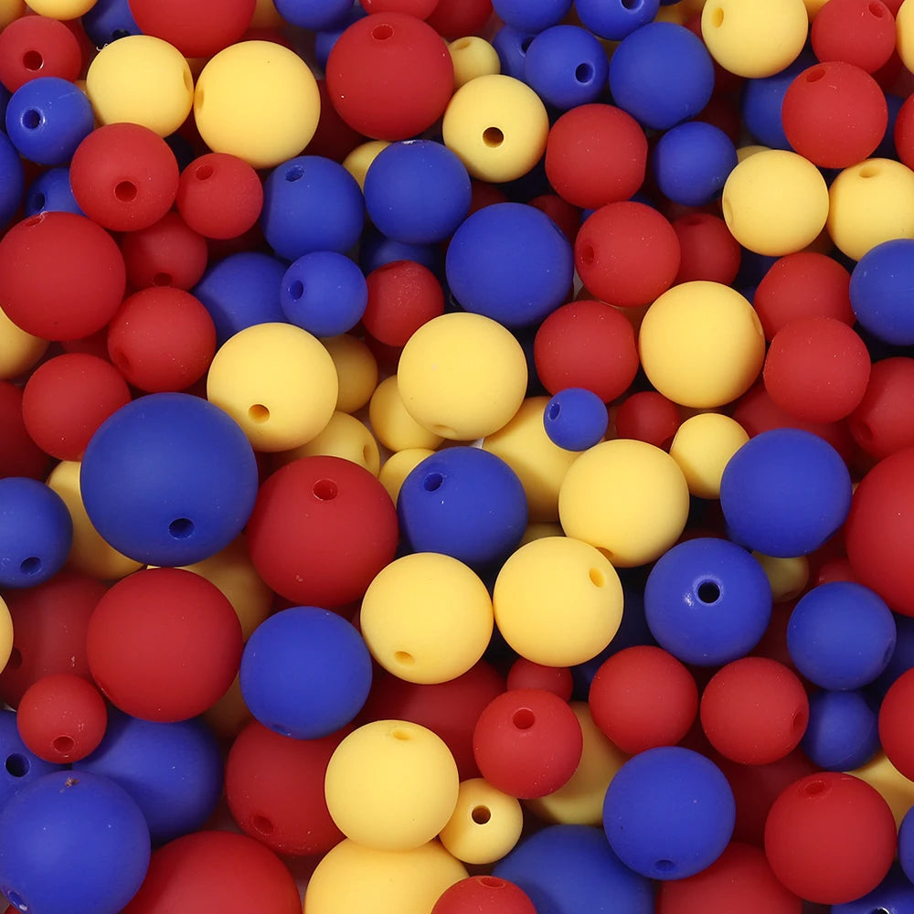 A close-up view of a pile of matte acrylic beads in various colors including red, yellow, blue, and pink.