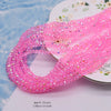 Pink faceted crystal rondelle beads for jewelry making displayed on a white plate.
