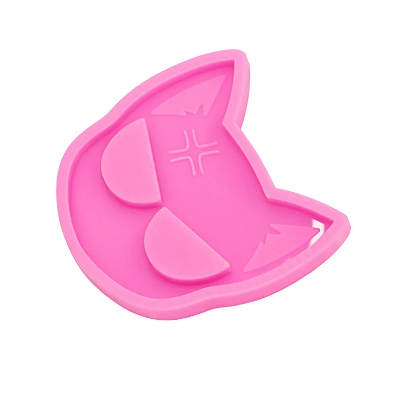 A pink silicone mold shaped like a cat head for DIY keychains and craft projects.