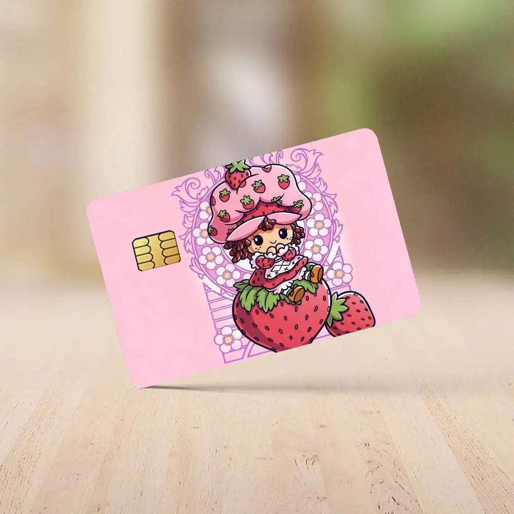 A pink credit card featuring a cute strawberry shortcake cartoon design with strawberries and a flower crown.