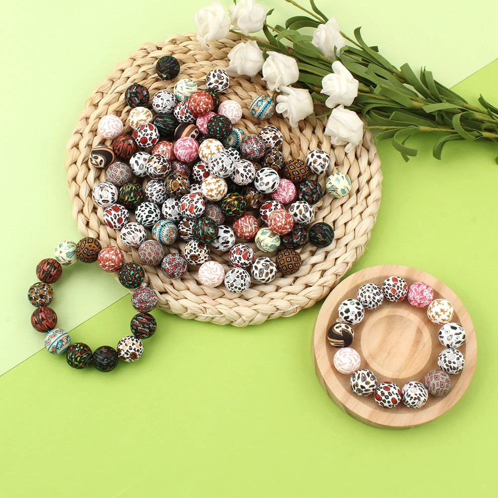 A collection of colorful printed silicone beads in various patterns is displayed on a woven mat and wooden plate.